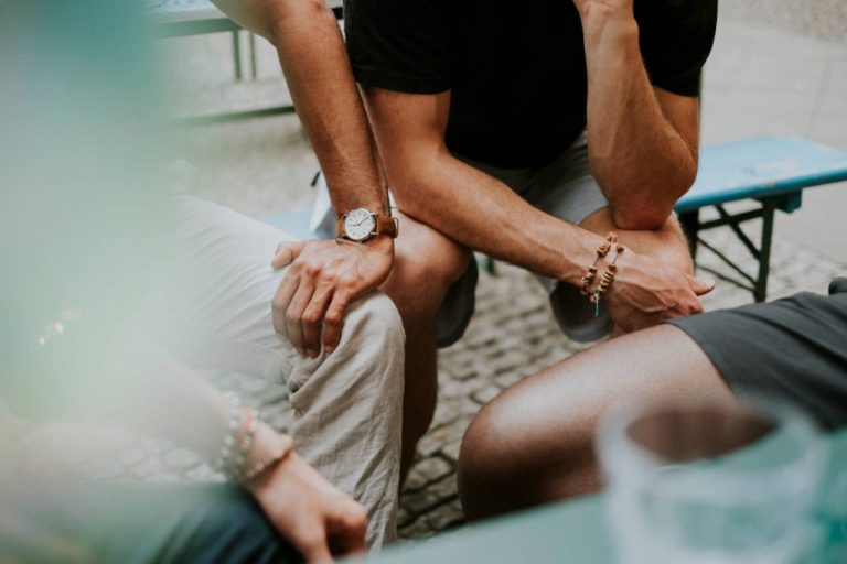 Therapy and Support Groups: three people sitting showing only their knees, hands, and arms